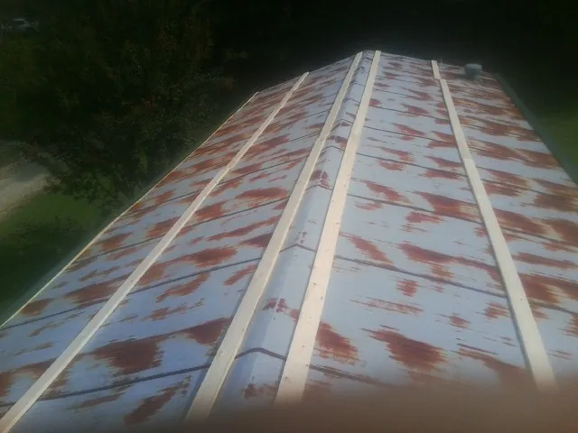 Rusted metal roof panels with new wood purlins before replacement — Storm Damage Roof Repair in Penfield by Roofing Brothers